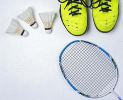 équipement de compétition de badminton, raquette de badminton, balle de badminton et chaussures sur fond de bois blanc photo