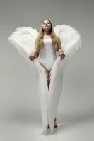 une fille ange romantique dans un body blanc avec des ailes blanches photo