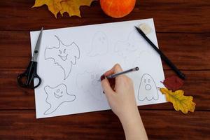 bricolage d'halloween. instructions étape par étape sur la façon de dessiner des fantômes amusants. photo