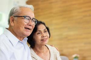 concept de soins infirmiers à domicile. couple de personnes âgées femme asiatique sont assis ensemble joyeusement. photo