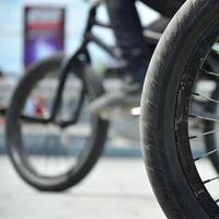 une roue de vélo bmx sur fond de rue floue avec des cyclistes. concept de sports extrêmes photo