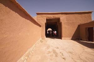 maison à tinghir, maison traditionnelle d'argile et de paille. maison en terre avec portes en acier bleu. une porte ouverte. photo