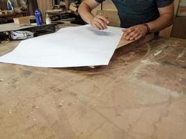 un charpentier anonyme travaillant sur un nouveau projet dans son atelier. vue de dessus de table d'un homme méconnaissable dessin n photo