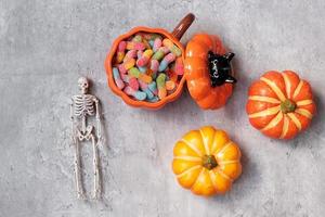 bonne journée d'halloween avec des bonbons fantômes, de la citrouille, un bol et des décorations. astuce ou menace, bonjour octobre, automne automne, concept festif, fête et vacances photo