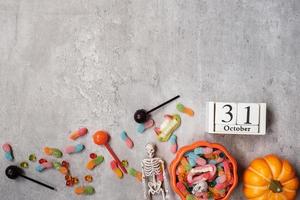 bonne journée d'halloween avec des bonbons fantômes, une citrouille, un bol et le calendrier du 31 octobre. tour ou menace, bonjour octobre, automne automne, concept festif, fête et vacances photo