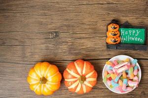 bonne journée d'halloween avec des bonbons fantômes, de la citrouille, un bol et des décorations. astuce ou menace, bonjour octobre, automne automne, concept festif, fête et vacances photo