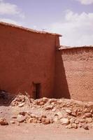 maison à tinghir, maison traditionnelle d'argile et de paille. maison en terre avec portes en acier bleu. une porte ouverte. photo