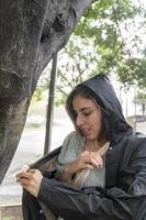 jeune femme mettant un imperméable sous une pluie soudaine et inattendue, s'abritant dans un arbre, humide, mexique photo