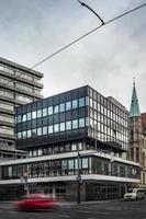 grand bâtiment moderne en verre dans le quartier chic du village technologique de l'ambassade, les travailleurs transportant une poubelle marchant vers le bâtiment photo