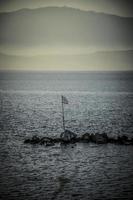 Un drapeau grec dans la mer à Céphalonie le soir photo