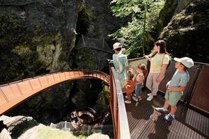 une mère avec des enfants se tient dans des escaliers métalliques dans le liechtensteinklamm ou la gorge du liechtenstein, en autriche. photo