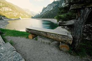 banc en bois contre le lac et les montagnes à vorderer gosausee, gosau, haute-autriche. photo