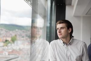 jeune homme d'affaires au bureau de démarrage près de la fenêtre photo