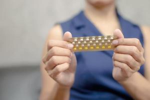 femme tenant des pilules contraceptives orales photo