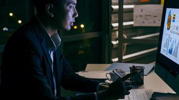un jeune homme d'affaires se concentrant sur une analyse de projets de travail dans son bureau jusque tard dans la nuit. photo