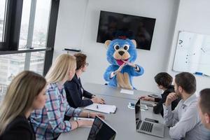 patron habillé en ours s'amusant avec des gens d'affaires dans un bureau branché photo