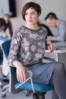 portrait d'une jeune femme d'affaires au bureau avec une équipe lors d'une réunion en arrière-plan photo