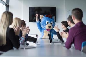 patron habillé en ours s'amusant avec des gens d'affaires dans un bureau branché photo