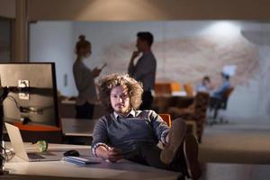 homme d'affaires assis avec les jambes sur le bureau au bureau photo