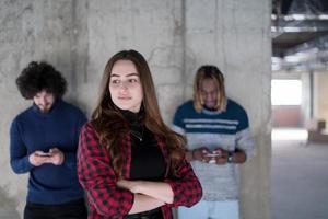 équipe commerciale multiethnique décontractée utilisant des téléphones portables devant un mur de béton photo