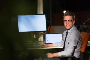 homme travaillant sur ordinateur dans un bureau sombre photo