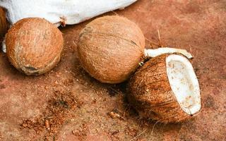 moitié de noix de coco mûre pelée coupée sur des fruits tropicaux moulus naturels pour le lait de coco photo