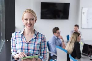 jolie femme d'affaires utilisant une tablette dans un immeuble de bureaux par fenêtre photo