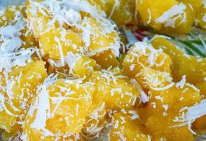 dessert thaï cuit à la vapeur gâteau de manioc jaune avec noix de coco râpée photo