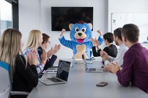 patron habillé en ours s'amusant avec des gens d'affaires dans un bureau branché photo