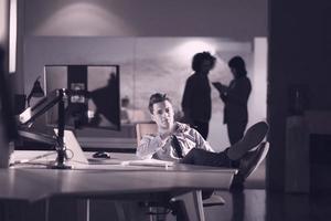 homme d'affaires assis avec les jambes sur le bureau au bureau photo