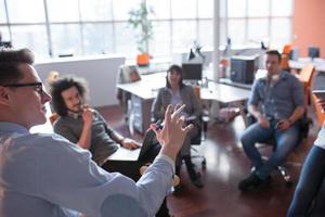 équipe de jeunes entreprises lors d'une réunion dans un immeuble de bureaux moderne photo