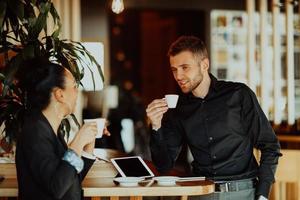 deux jeunes en pause de travail dans un café prennent une pause des obligations quotidiennes. photo