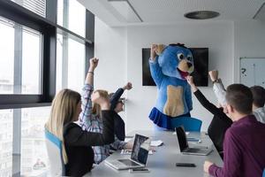 patron habillé en ours s'amusant avec des gens d'affaires dans un bureau branché photo