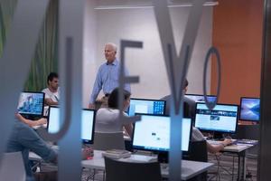 groupe d'étudiants en technologie travaillant dans une salle de classe d'école de laboratoire informatique photo