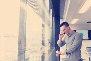 jeune homme d'affaires parlant au téléphone intelligent au bureau photo