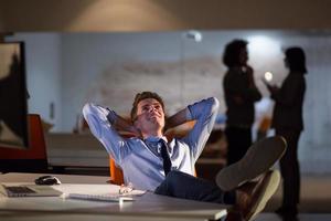 homme d'affaires assis avec les jambes sur le bureau au bureau photo