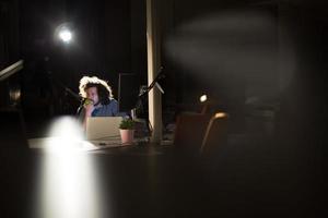 homme travaillant sur ordinateur dans un bureau sombre photo