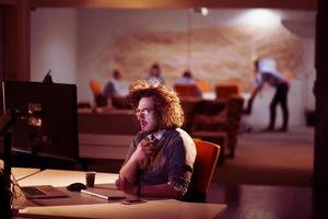 homme travaillant sur ordinateur dans un bureau sombre photo