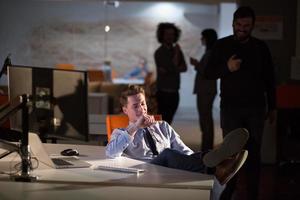 homme d'affaires assis avec les jambes sur le bureau au bureau photo