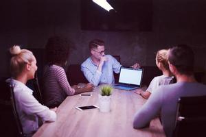 équipe commerciale de démarrage multiethnique au bureau de nuit photo