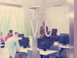 enseignant principal et groupe d'étudiants dans une salle de classe de laboratoire informatique photo