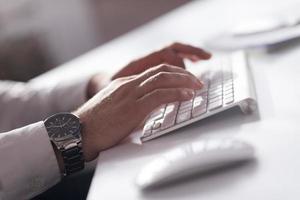 mains tapant sur un ordinateur de bureau photo