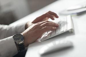 mains tapant sur un ordinateur de bureau photo