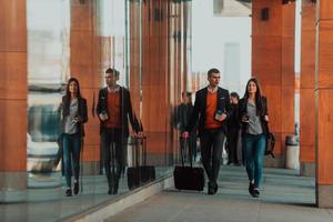 homme d'affaires et femme d'affaires parlant et tenant des bagages voyageant en voyage d'affaires, transportant du café frais dans leurs mains. concept d'entreprise photo