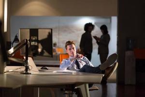 homme d'affaires assis avec les jambes sur le bureau au bureau photo