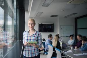 jolie femme d'affaires utilisant une tablette dans un immeuble de bureaux par fenêtre photo