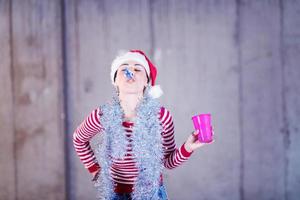 jeune femme d'affaires portant un chapeau rouge et soufflant un sifflet de fête photo