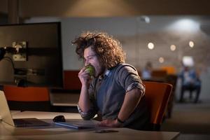 homme qui mange une pomme dans son bureau photo