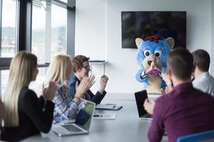 patron habillé en ours s'amusant avec des gens d'affaires dans un bureau branché photo