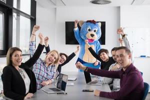 patron habillé en ours s'amusant avec des gens d'affaires dans un bureau branché photo